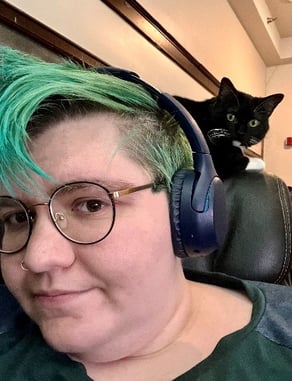 Hannah Sandeen with cat working behind her on chair.