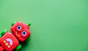 Red robot toy on green background.